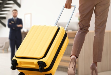 Image of Businesswoman with suitcase arriving to hotel, closeup view