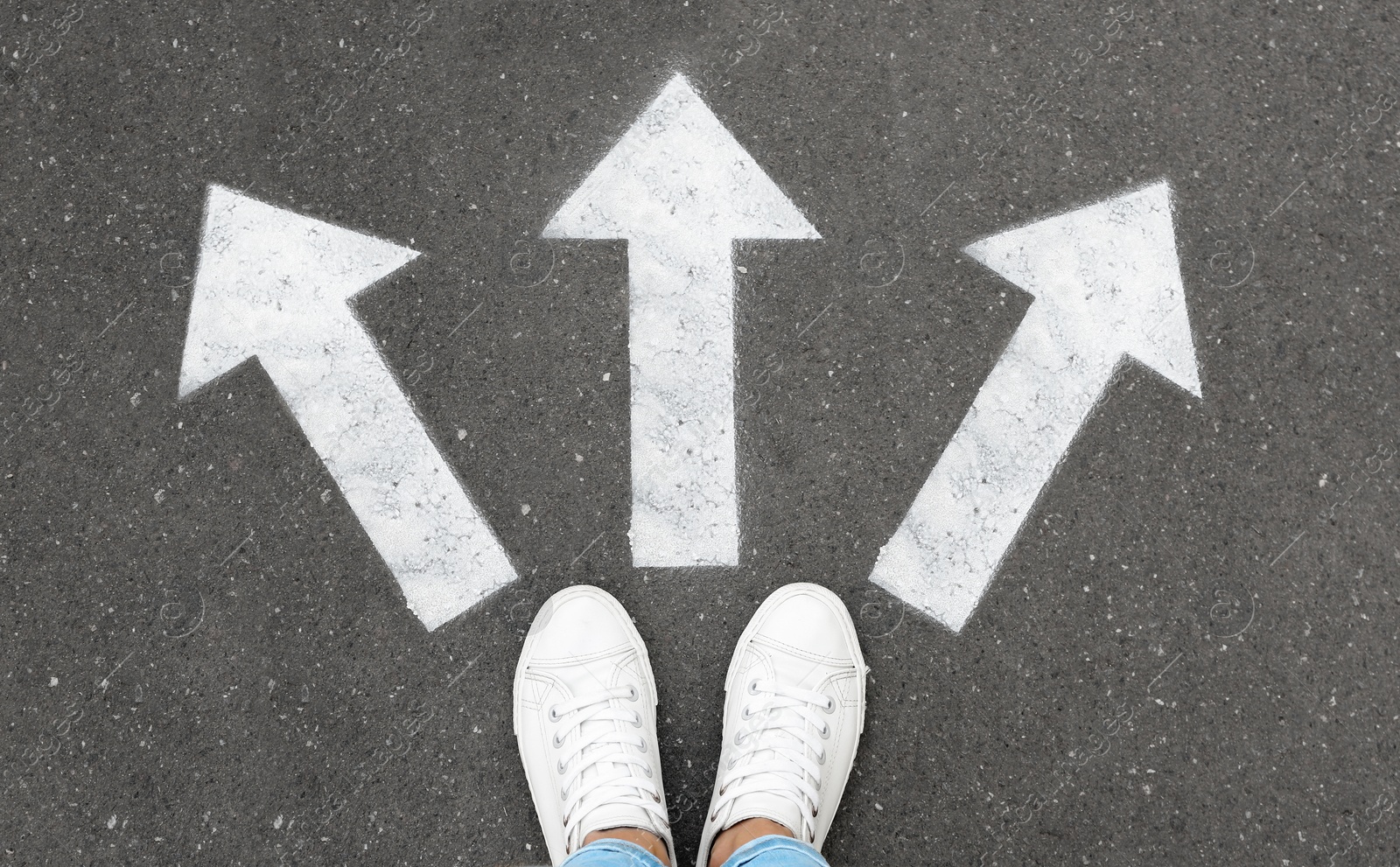 Image of Woman standing on road near arrows, top view 