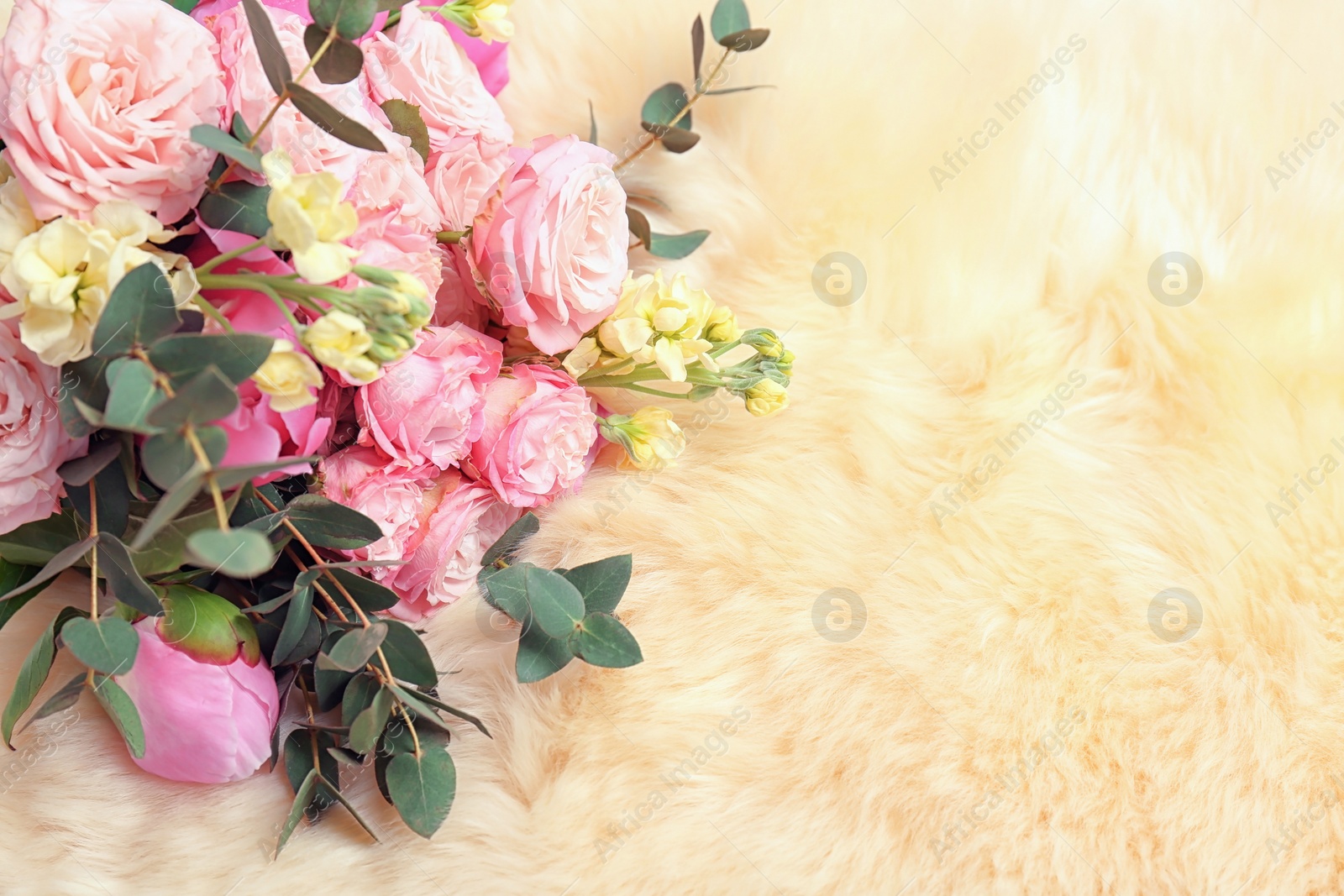 Photo of Bouquet of beautiful fragrant flowers on furry fabric