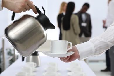 Photo of Waitress pouring hot drink during coffee break, closeup