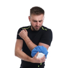 Young man with cold compress suffering from elbow pain on white background