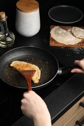 Photo of Woman cooking chebureki in frying pan, closeup
