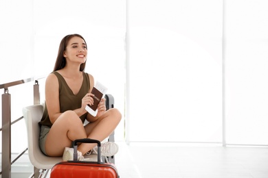 Photo of Young woman with suitcase in airport