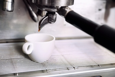 Photo of Preparing fresh aromatic coffee using modern machine, closeup