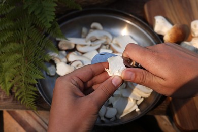 Photo of Man slicing mushrooms at table, closeup view
