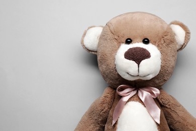 Cute teddy bear on grey background, top view. Space for text