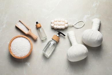 Photo of Flat lay composition with herbal massage bags and other spa products on light grey marble table