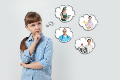 Image of Thoughtful little girl choosing future profession on light background
