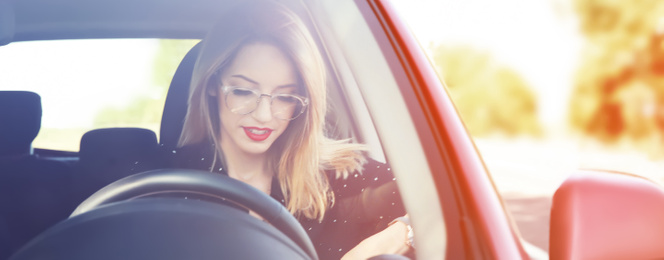 Young woman sitting in modern car on sunny day. Banner design