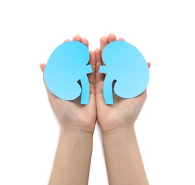 Photo of Woman holding paper cutout of kidneys on white background, top view