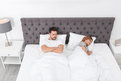 Couple with relationship problems in bed at home