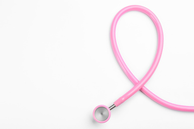 Photo of Pink stethoscope isolated on white, top view. Breast cancer awareness