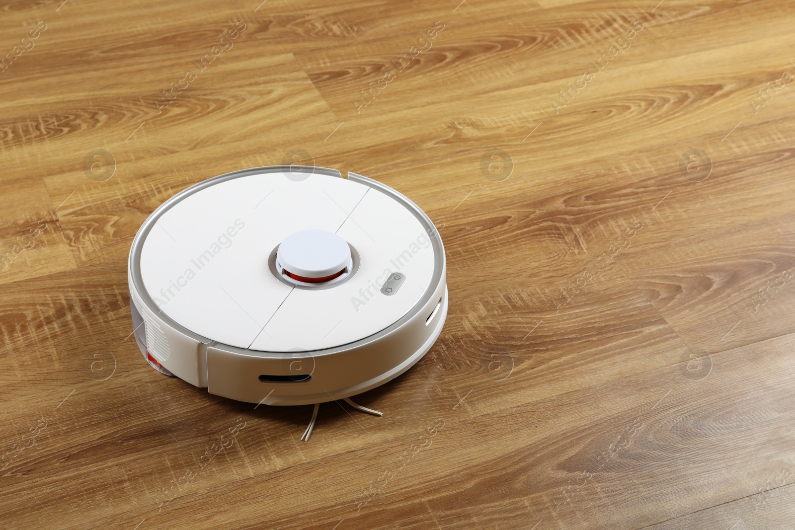 Photo of Robotic vacuum cleaner on wooden floor, space for text