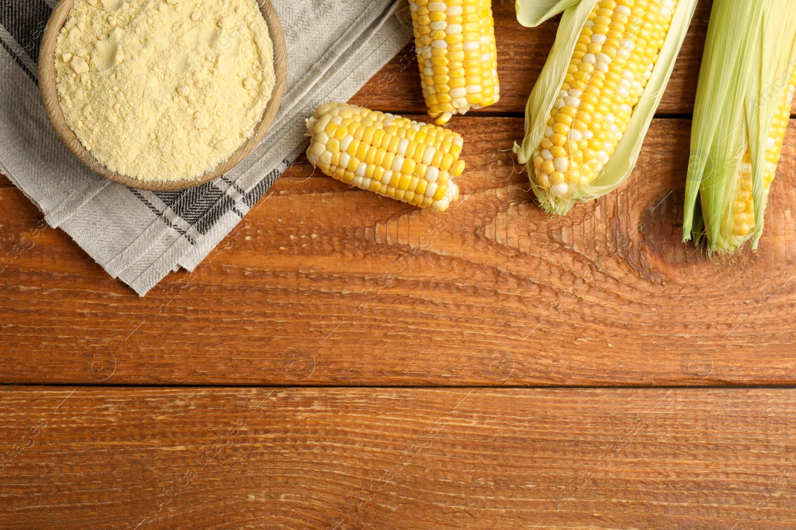 Photo of Flat lay composition with corn flour on wooden table, space for text