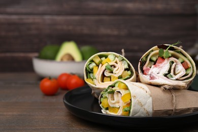 Photo of Delicious sandwich wraps with fresh vegetables on wooden table, space for text