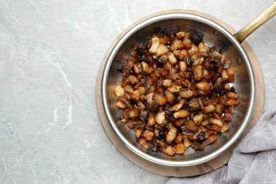 Photo of Tasty fried cracklings on light marble table, flat lay with space for text. Cooked pork lard