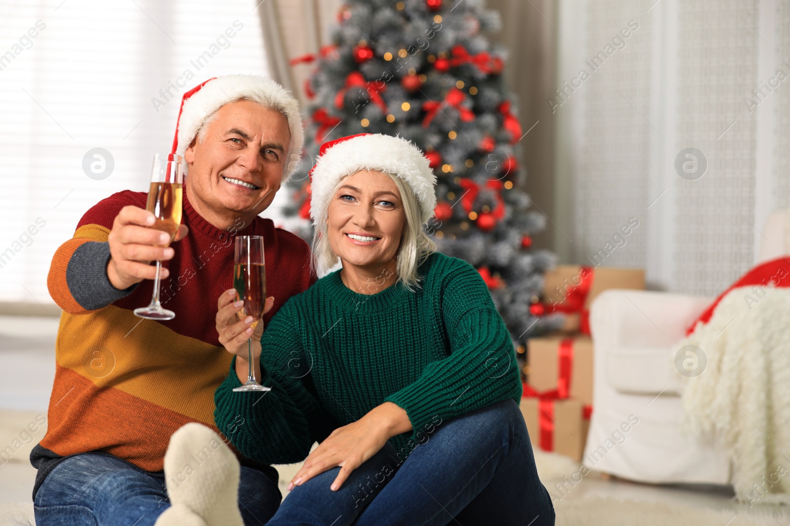 Photo of Happy mature couple with glasses of champagne at home. Christmas celebration