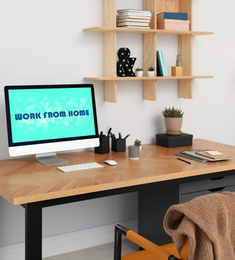 Image of Modern computer with text WORK FROM HOME on table in office 