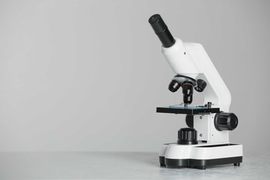 Photo of Modern microscope on grey background. Space for text