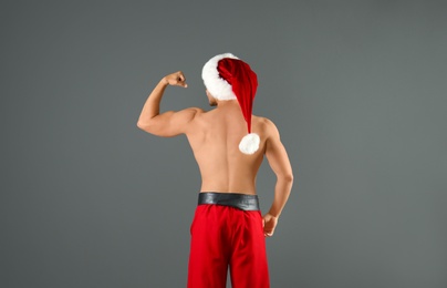 Shirtless young Santa Claus with sexy body on color background