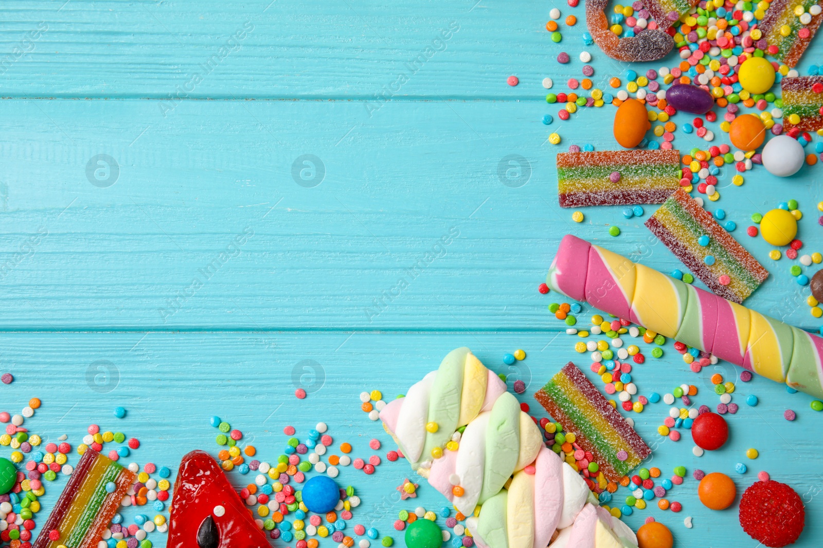 Photo of Flat lay composition with different yummy candies and space for text on color wooden background