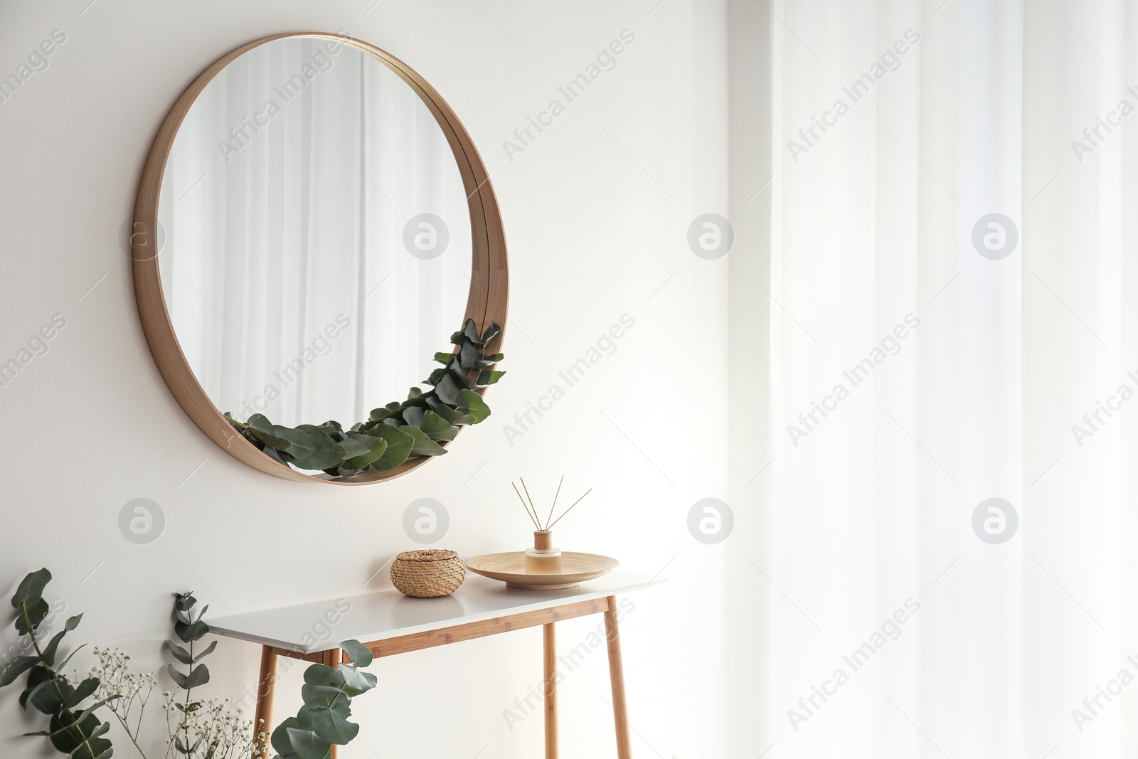 Photo of Round mirror with wooden frame in light room