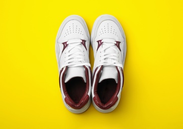 Photo of Pair of stylish shoes on yellow background, top view