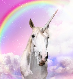 Image of Magic unicorn in beautiful sky with rainbow and fluffy clouds. Fantasy world