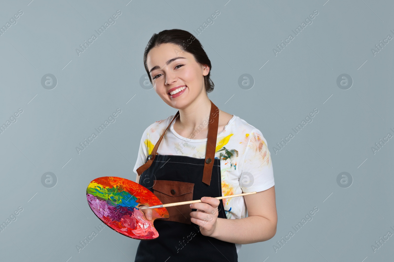 Photo of Woman with painting tools on grey background. Young artist