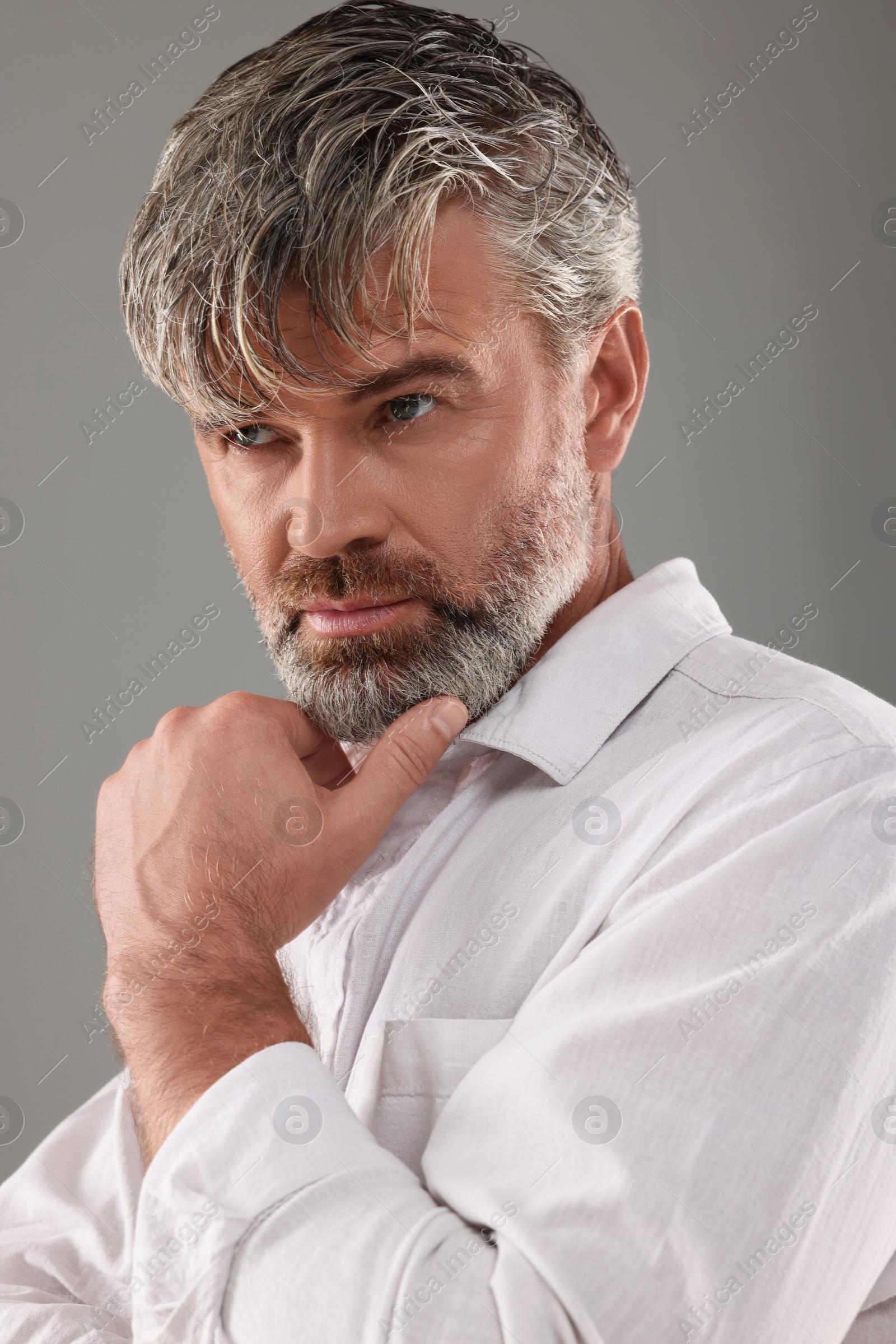 Photo of Portraitconfident man with beautiful hairstyle on light grey background