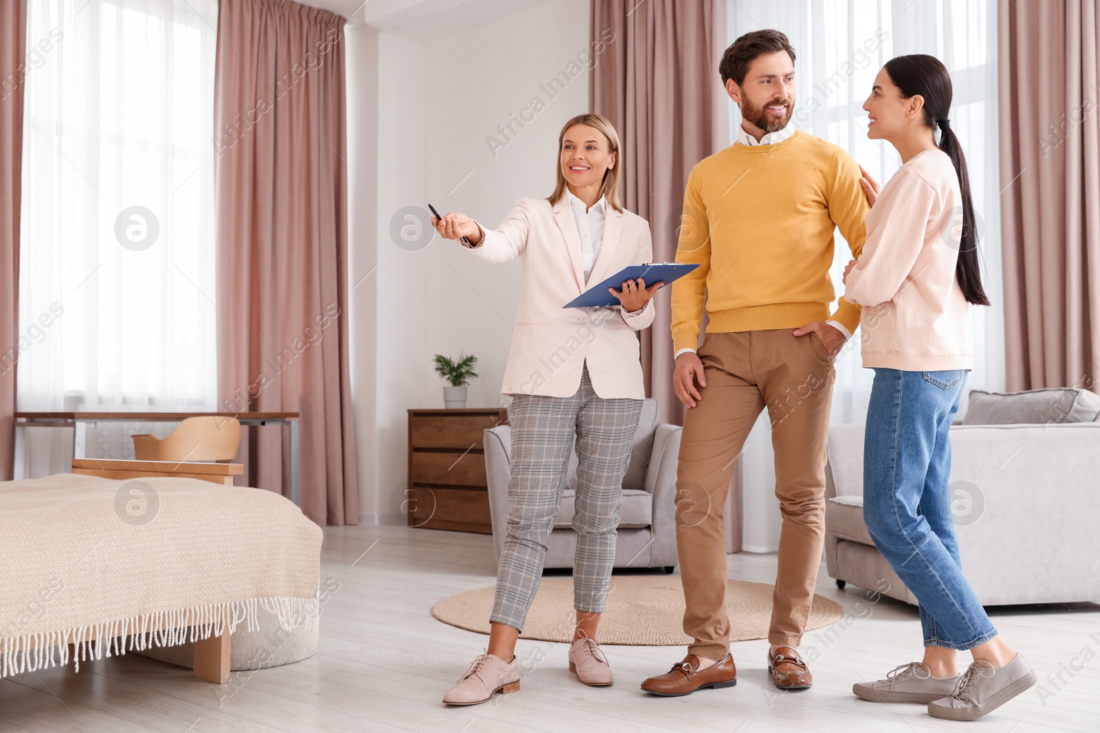 Photo of Real estate agent working with couple in new apartment