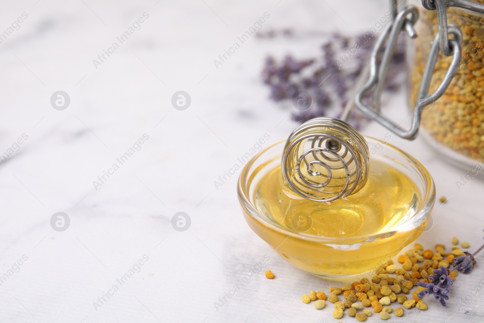 Photo of Fresh honey in bowl, dipper, bee pollen granules and lavender on light table, closeup. Space for text