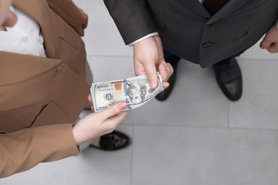 Man giving money to woman indoors, above view. Currency exchange