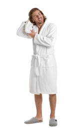 Young man in bathrobe drying hair with towel on white background
