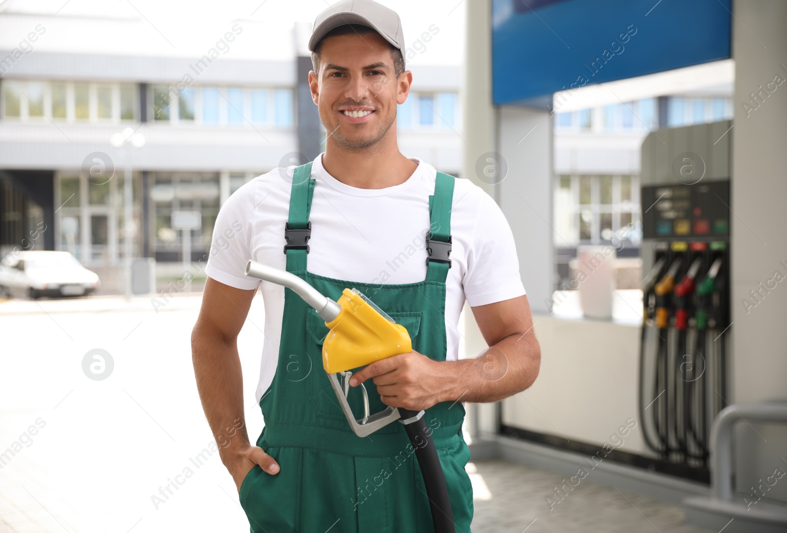 Photo of Worker with fuel pump nozzle at modern gas station