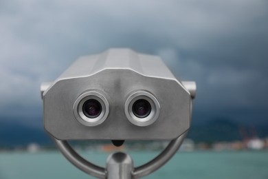 Metal tower viewer installed near sea, closeup. Mounted binoculars