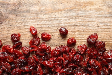 Tasty cranberries on wooden background, top view with space for text. Dried fruit as healthy snack