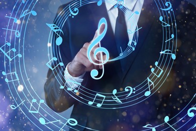 Image of Musician pointing at staff with music notes and symbols on color background, closeup