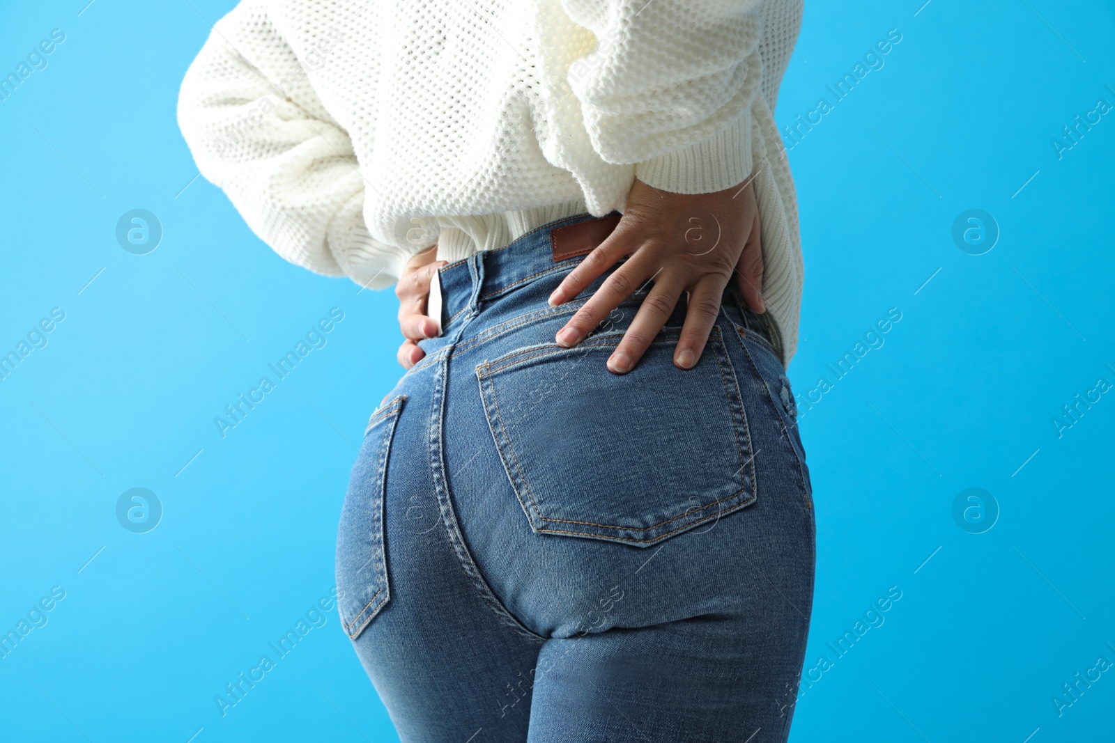 Photo of Woman wearing jeans on blue background, closeup