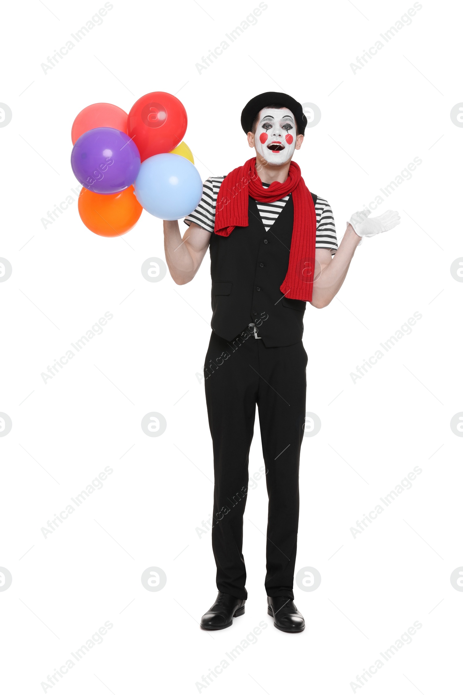 Photo of Funny mime artist with balloons posing on white background