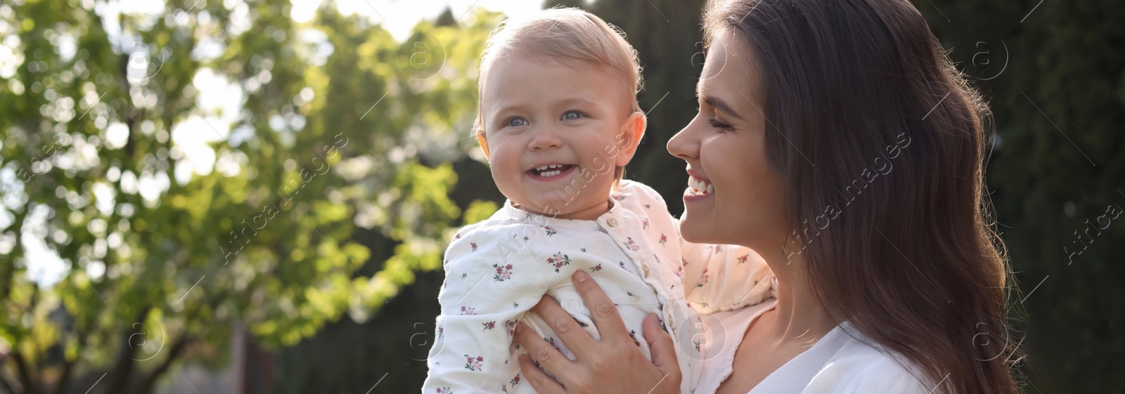 Image of Happy mother with her cute baby in park on sunny day, space for text. Banner design