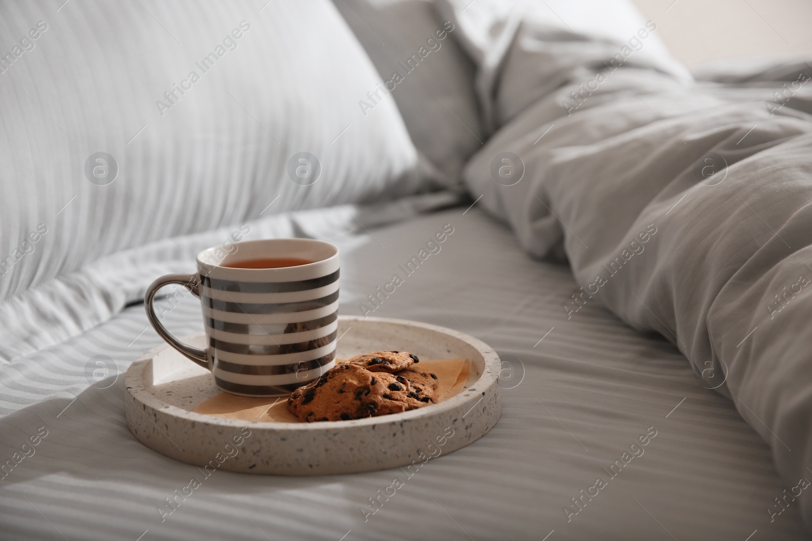 Photo of Tray with breakfast and soft blanket on bed, closeup