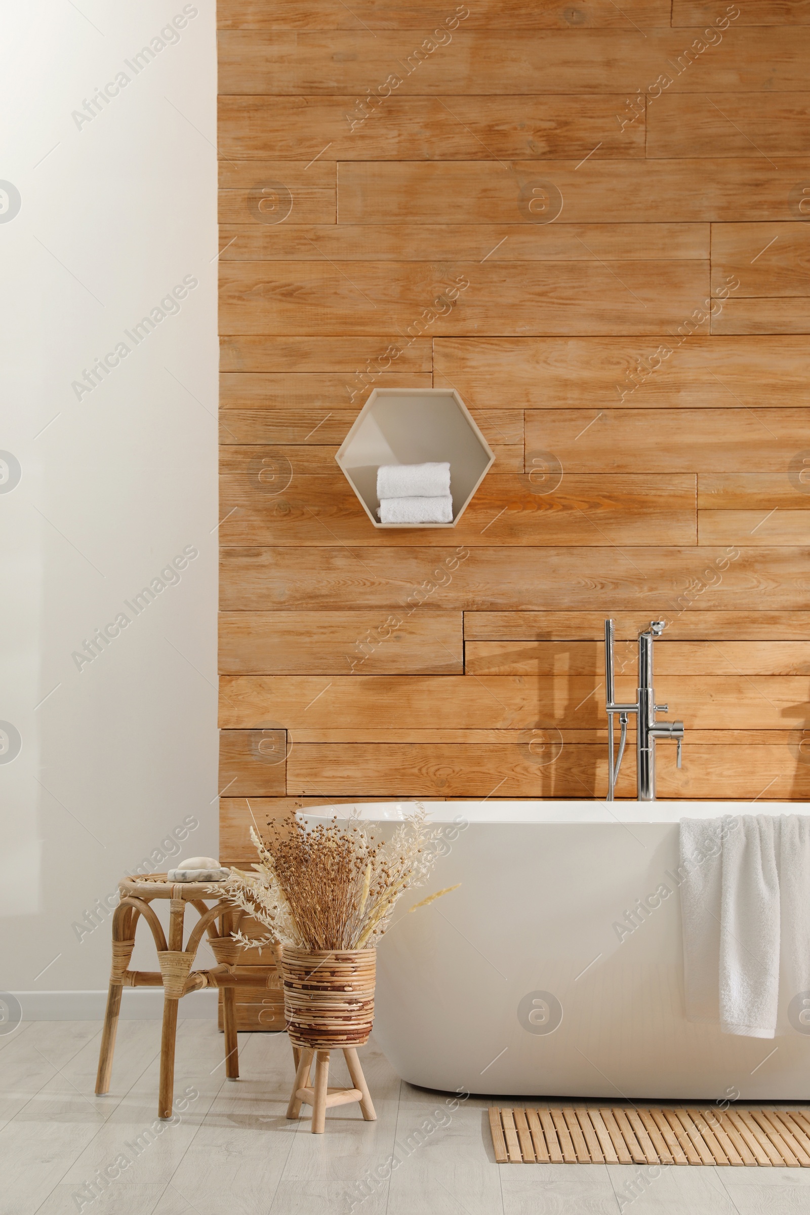 Photo of Bathroom interior with white tub and decor near wooden wall