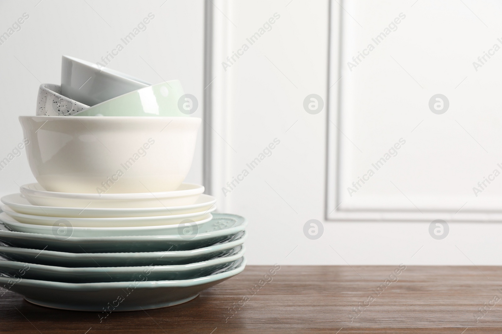 Photo of Beautiful ceramic dishware on wooden table, space for text