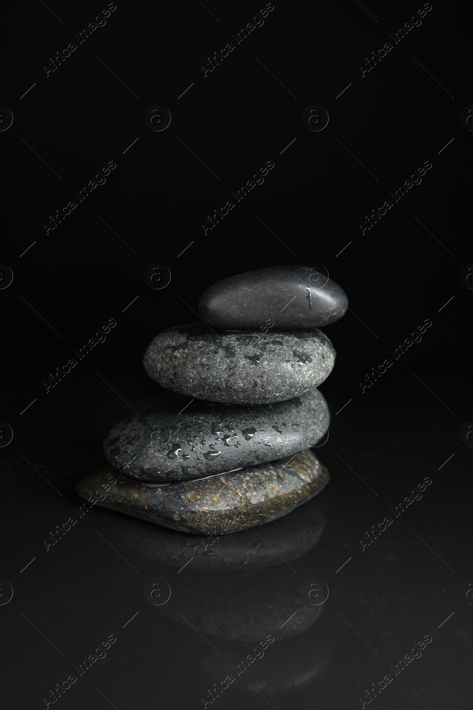 Photo of Stones in water on black background. Zen lifestyle