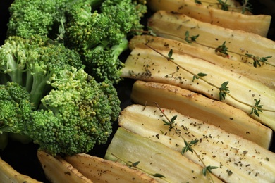 Photo of Raw white carrot and broccoli with thyme as background, closeup