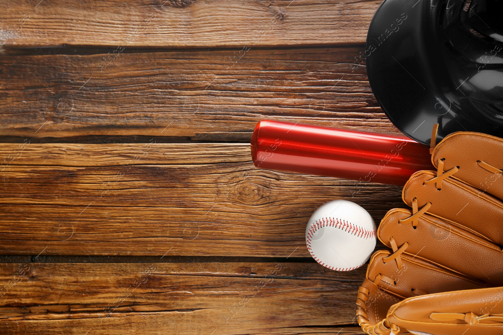 Photo of Baseball glove, bat, ball and batting helmet on wooden table, flat lay. Space for text