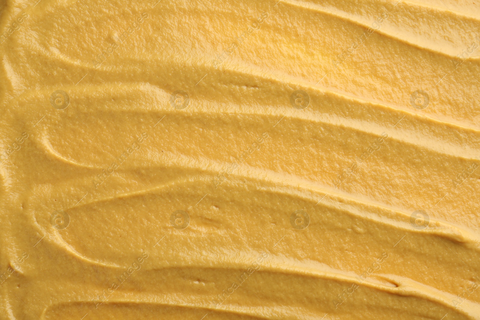 Photo of Fresh tasty mustard sauce as background, top view