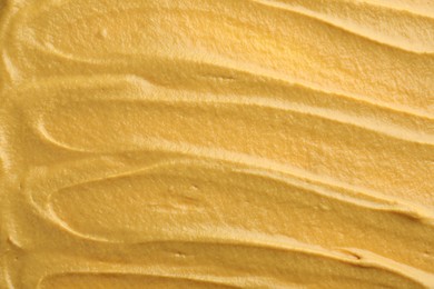 Photo of Fresh tasty mustard sauce as background, top view