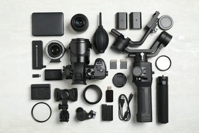 Photo of Flat lay composition with camera and video production equipment on light background